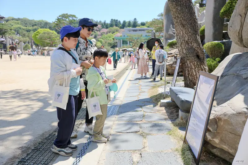 생명을 사랑하라 바위 앞에 시 액자가 줄지어 놓인 전시 전경
